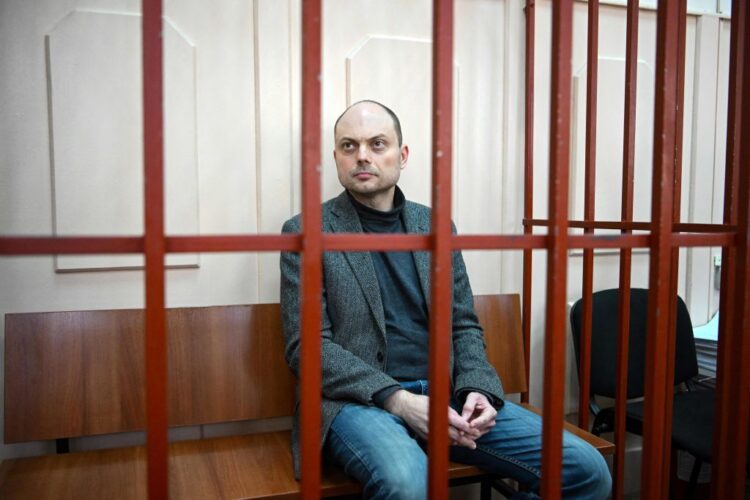 Russian opposition activist Vladimir Kara-Murza sits on a bench inside a defendants' cage during a hearing at the Basmanny court in Moscow on October 10, 2022. - Vladimir Kara-Murza was jailed in April for denouncing the Kremlin's Ukraine offensive and has been charged last week with high treason - the charges which could keep him behind bars for two decades. (Photo by NATALIA KOLESNIKOVA / AFP) (Photo by NATALIA KOLESNIKOVA/AFP via Getty Images)