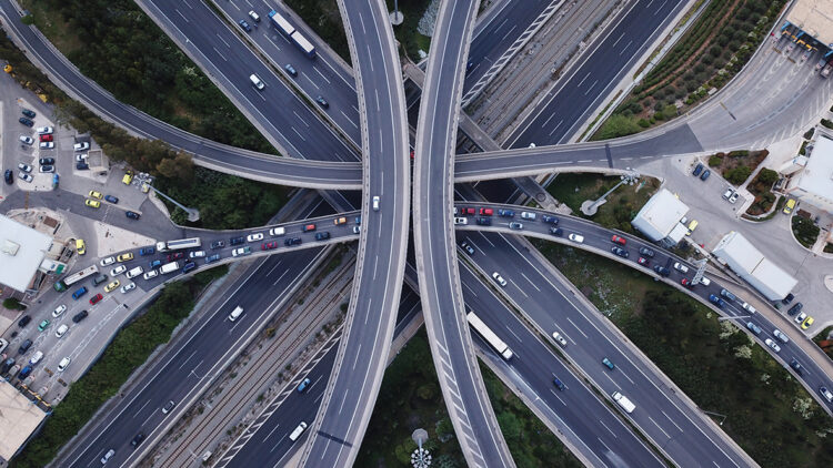 Aerial photo of multilevel elevated highway junction highway passing through modern city in multiple directions