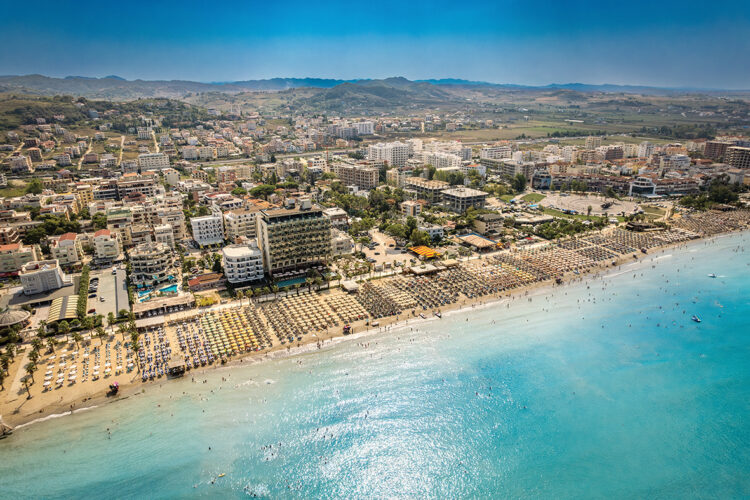 Golem, Durres, Albania - 22 august 2023: Aerial view to sandy beach full of umbrellas and people in summer season 2023