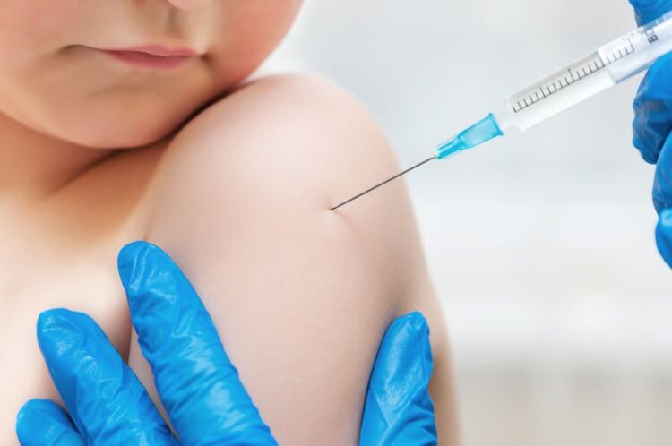 27527365 - boy and vaccine syringe