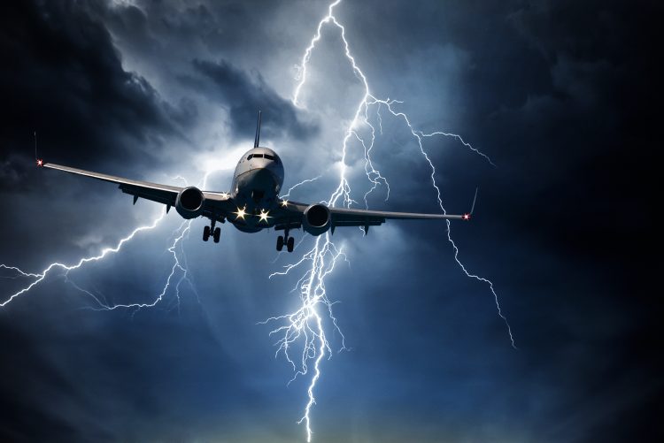 Passenger airplane travelling through sky against stormy bolt cloudscape
