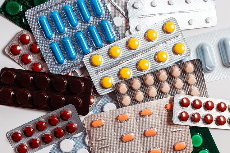 Pharmaceutical blister packs. A pile of pills in blister packs. Blister packs full of multi-colored pills isolated on a white background. Full colored pills package. Pack of pills with tablets.